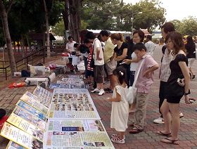 游客在观看展板，签名谴责中共迫害