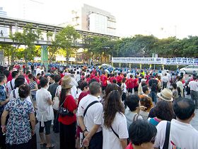 法轮功学员组成的天国乐团经过一零一大楼前时，大陆游客争相观看