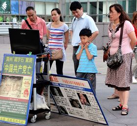 游客聚精会神地看着法轮功真相影片