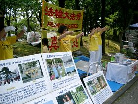 法轮功学员在稻泽市第十七届夏季活动节展位上炼功