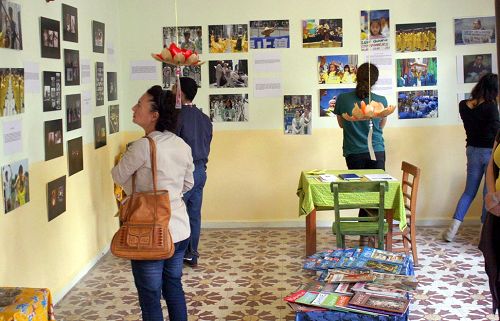 '参观者聚精会神地观看法轮功真相图片展每一幅照片'