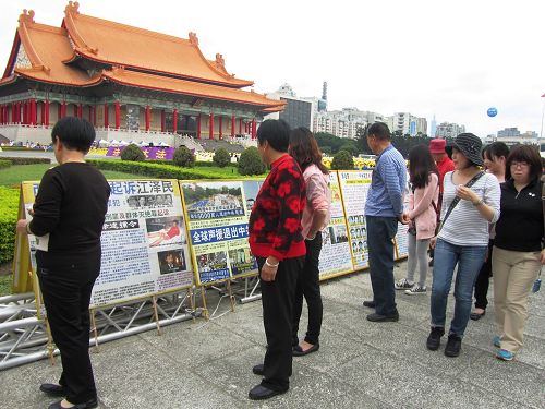 图2-3：主场周边排列的真相照片，帮助人们了解法轮功洪传世界盛况、以及中共残酷迫害的真相，许多明白真相的中国人把握良机办三退。