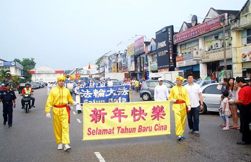 '大年初九，法轮功学员首次来到柔佛州新山的士古来大学城举行新年游行，在雨过天晴后，队伍在警方协助开路下浩荡出发。'