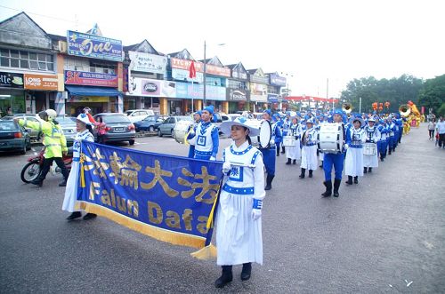 '法轮功游行队伍走在士古来大学城主要大街上，不但传播着法轮功的真相，也给当地民众带来过年的喜庆。'