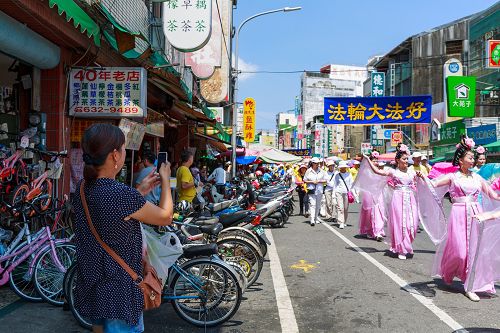 洪法队伍中美丽的仙女队展现大法美好，普受民众喜爱，纷纷高举着手机拍照留念。