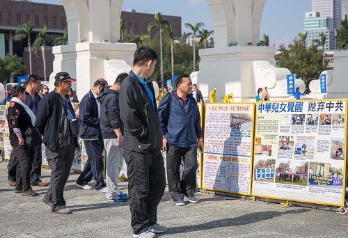 仔细观看真相展版的大陆游客。