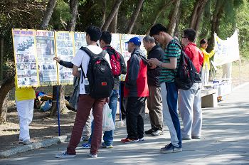 大陆游客认真阅读法轮功真相展板