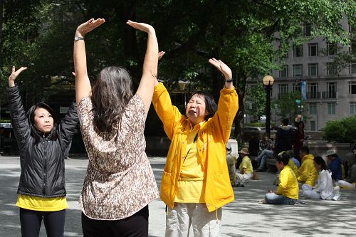 法轮功学员奈里（右）在教巴西人特瑞妮（中）炼法轮功