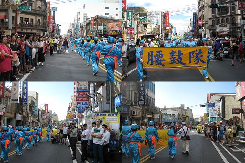 人们围在道路两旁观看腰鼓队的表演，并拍照。