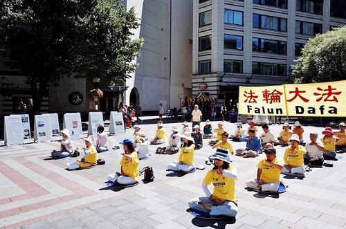 图2：西雅图法轮功学员在西湖中心（WestlakeCenter）广场前展示五套功法。