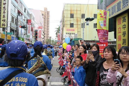 '图3～4：街道两侧聚集众多民众，纷纷拍照，拍手叫好。'