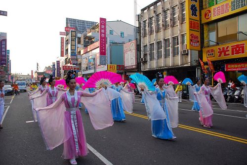 '图3：法轮功学员组成的仙女队跟着乐团，沿路赠送纸莲花，带来喜庆气息'