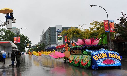 图4：电视台和观众冒雨拍摄法轮功学员游行队伍。