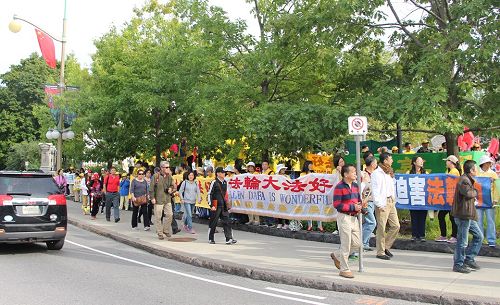 图6：总督府门前，大陆旅游团经过法轮功的打横幅队伍，有人现场做了三退。