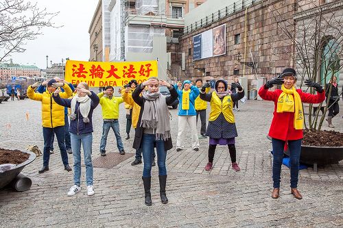 '图1：瑞典法轮功学员在斯德哥尔摩最热闹的皇宫旁的钱币广场举办法轮大法信息日活动。图为法轮功学员正在演示第二套功法——法轮桩法。'