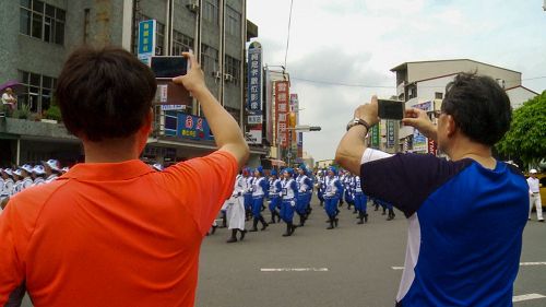 '图4：很多市民拿手机争相对着行进中的天国乐团拍照。'