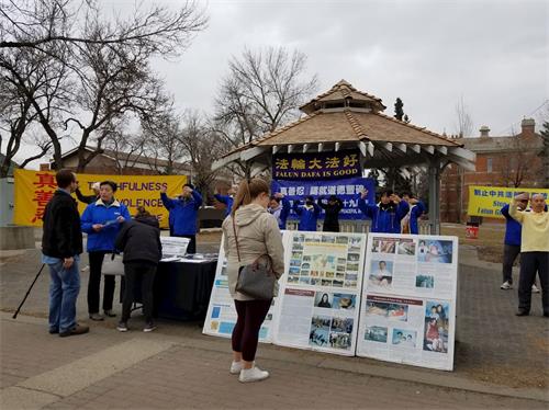 '图1：市民被法轮功学员祥和的功法吸引，开始驻足观看展板。'