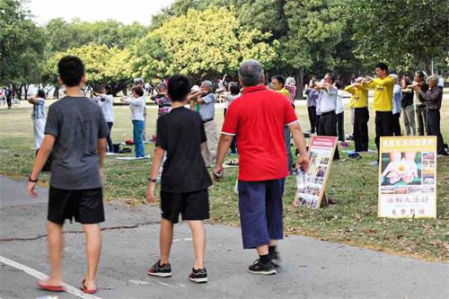 '图4：高雄学员分批分地举办庆祝活动，在凤山卫武营向民众展示祥和优美的五套功法，吸引不少散步的民众驻足观看，了解真相。'