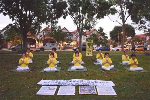 '图11：七月十九日早上，柔佛州新山开屏花园（Taman Pelangi Indah）的部份法轮功学员在炼功点举行悼念活动，希望更多的民众能了解真相。'