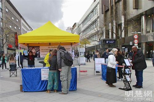 '图1：二零二一年十月十六日，法轮功学员在德国汉诺威（Hannover）中心火车站附近的步行街举办了信息日活动，向当地居民介绍法轮功的真相。'