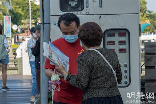 '图9：一位常在莲池潭四周步行运动的餐饮业厨师，被纯净的炼功画面吸引驻足观看，并表示他回去会再上网深入了解法轮功。'