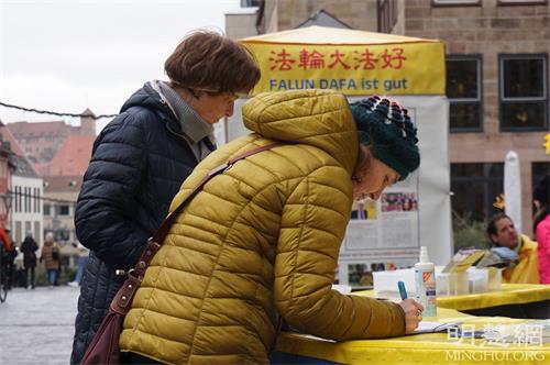 '图2～4：二零二二年一月十五日，弗兰肯地区的部份学员在纽伦堡传播真相，民众了解真相后，签名支持法轮功学员反迫害。'