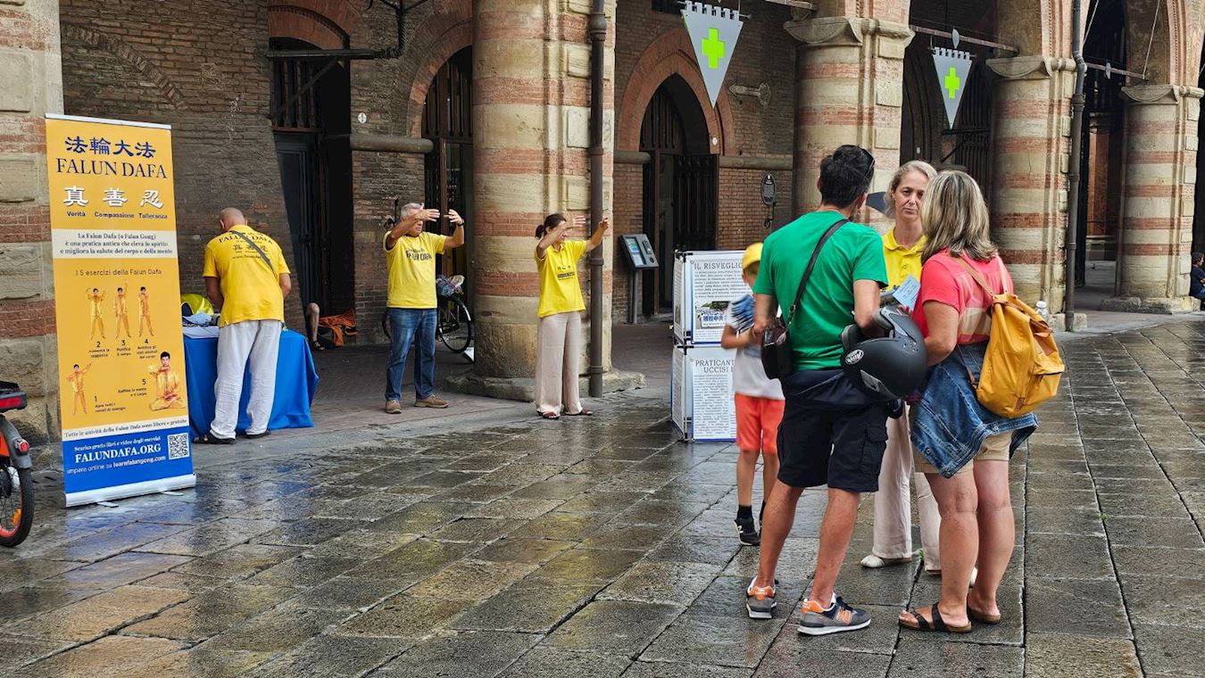 '图1~3:在博洛尼亚(Bologna),法轮功学员们在细雨绵绵中向过往民众传播大法真相。'